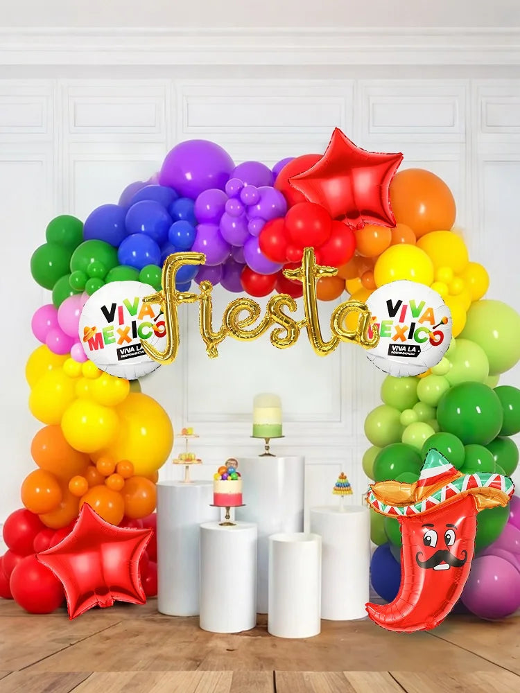 Colorful balloon arch with 'Viva Mexico' and 'Fiesta' decorations on a white wall background.